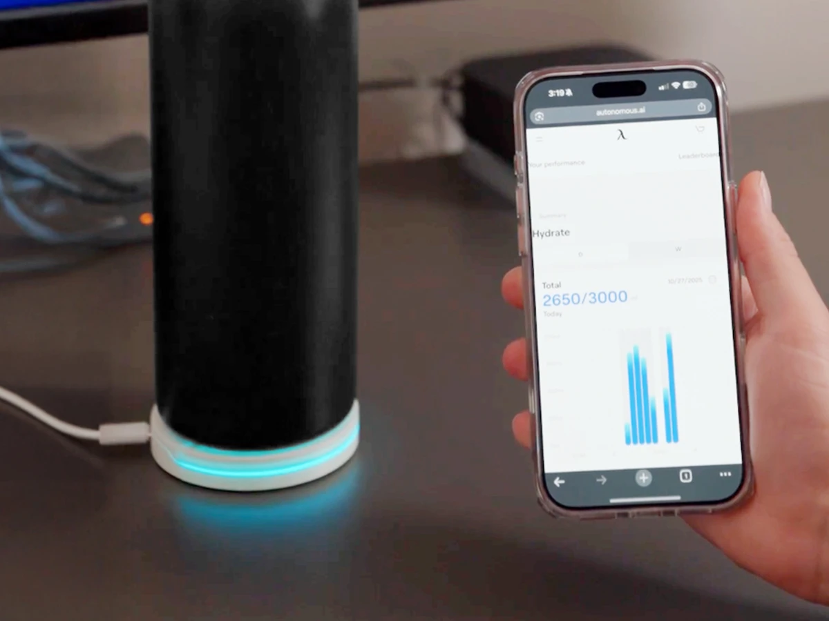 White Autonomous Hydrate coaster under a bottle, with daily water totals in the phone app