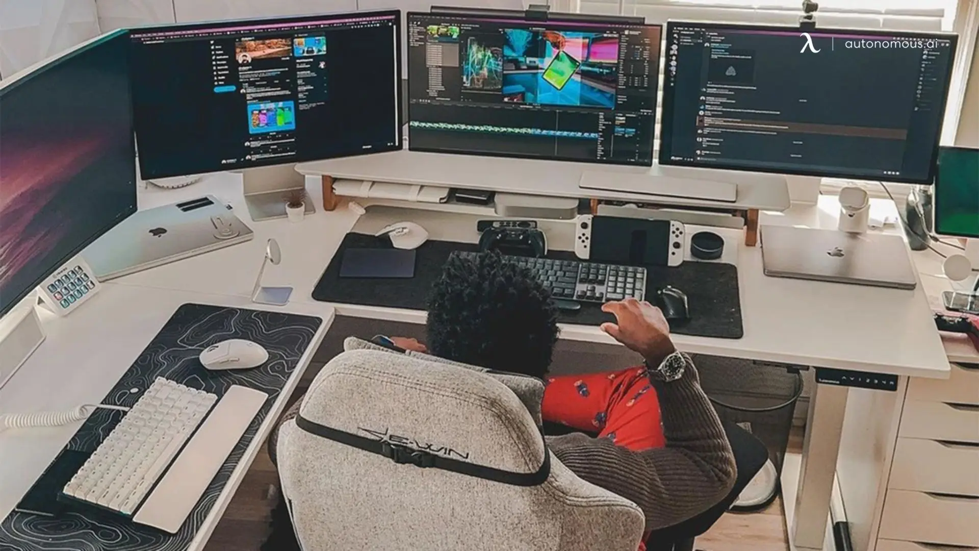 black and white gaming setup with white L-shaped standing desk and four monitors