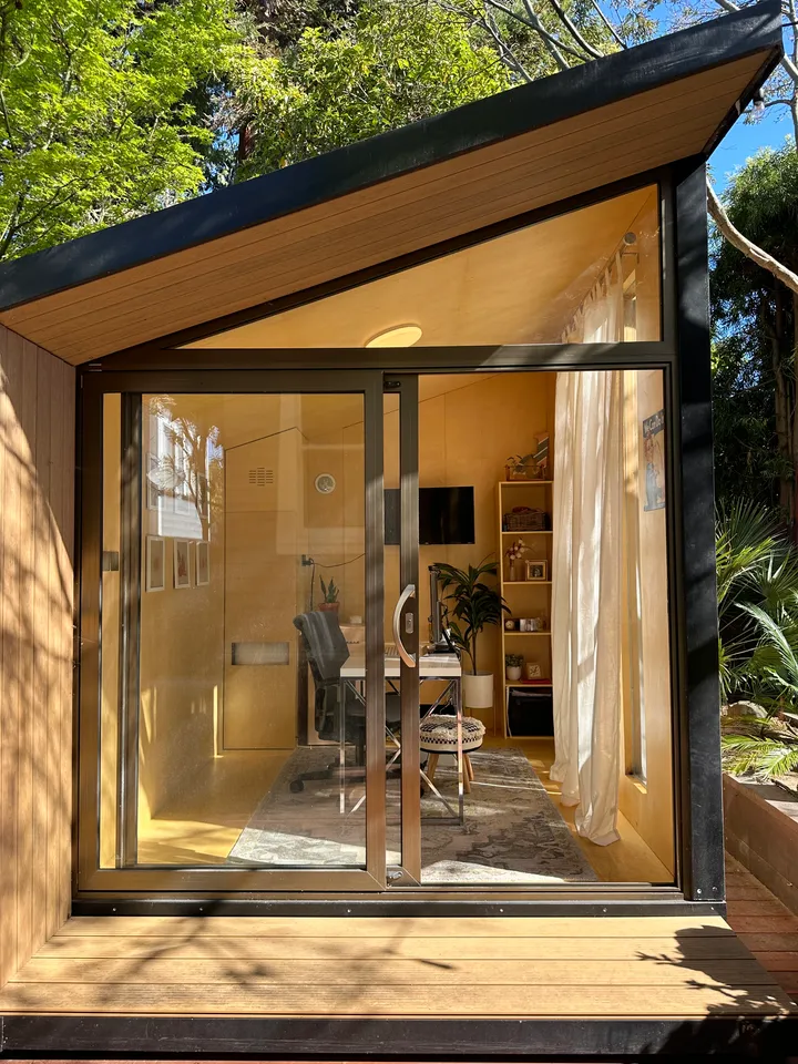 Open sliding doors showing a home office inside a wood WorkPod