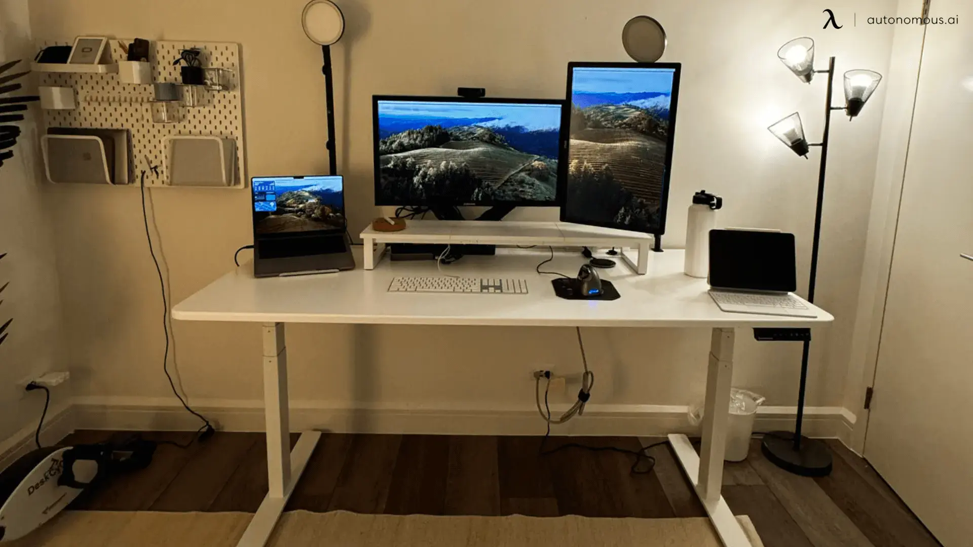 Warm wood desk with several displays and simple home-office accessories