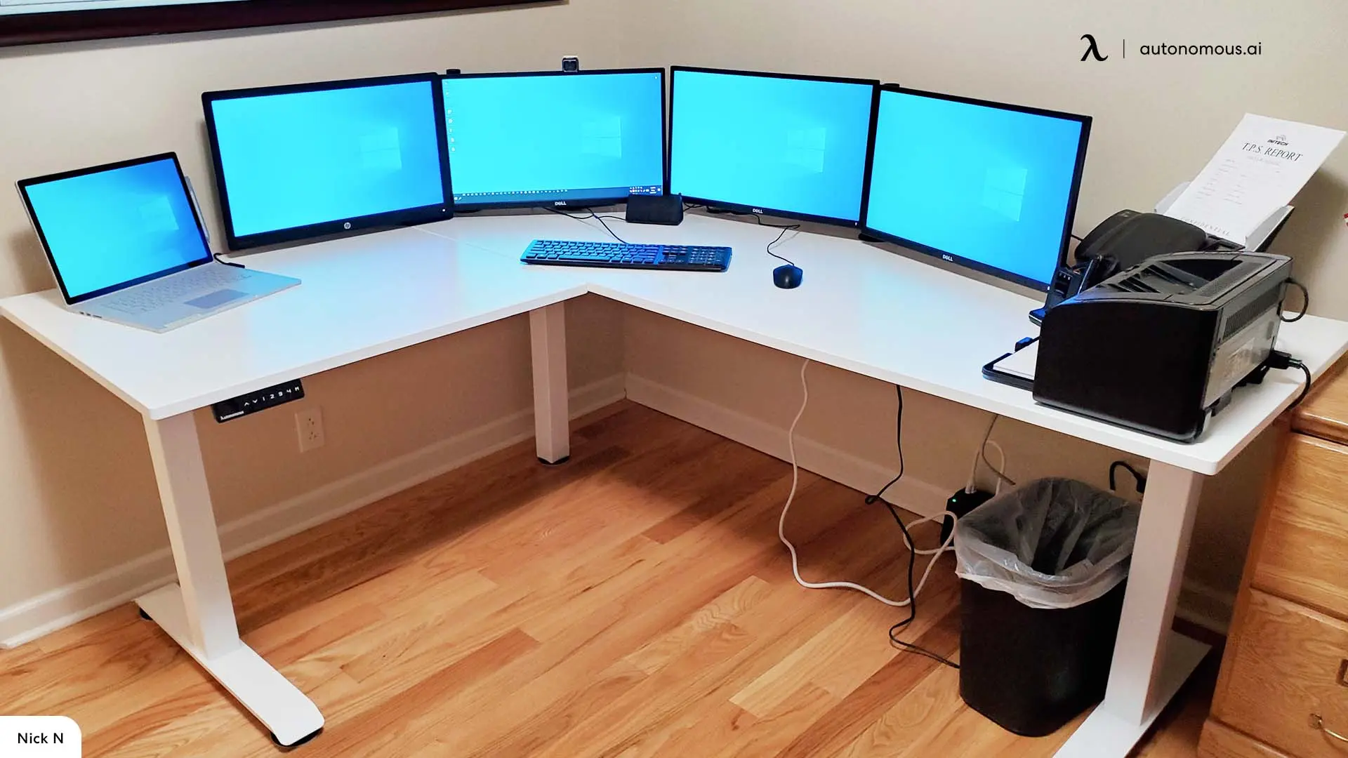Light wood corner workstation with multiple blue-lit monitors